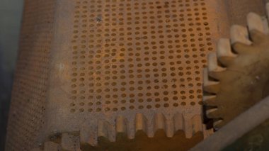 Delikli kalın demir nesne, köşede, odaklanmamış arka dişli 