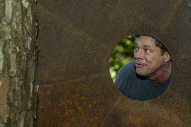  Bir reklam ve ticari proje için bir alanı işaret eden güzel ve mutlu bir adam, kahverengi demir plaka içinde. 