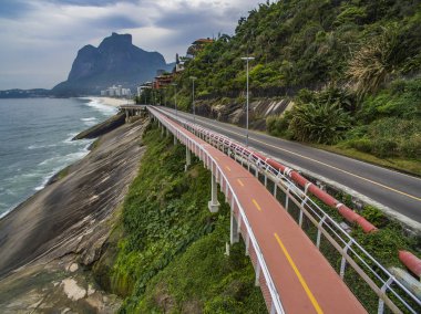Karayolu deniz kenarında. Harika yolu ve bisiklet yolu. Bisiklet ve yol parça ve mavi denizin içinde Rio de Janeiro şehrine yanında. Tim Maia bisiklet yolu üzerinde Niemeyer Avenue, Rio de Janeiro, Brezilya, Güney Amerika. 