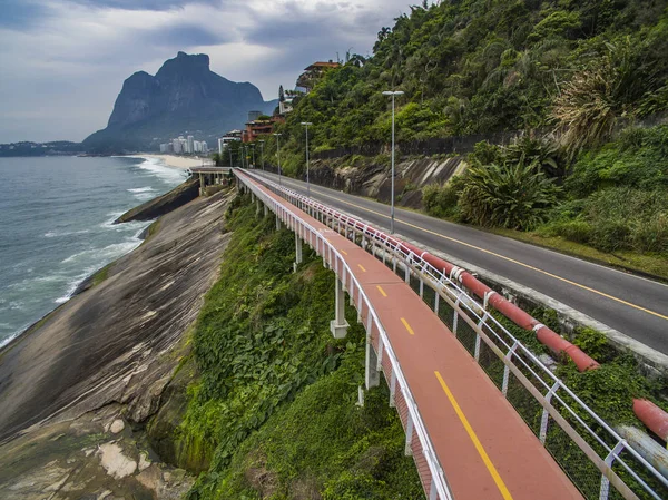 Highway by the sea. Wonderful road and bike path. Bicycle and road track and next to the blue sea in the city of Rio de Janeiro. Tim Maia bike path on Niemeyer Avenue, Rio de Janeiro, Brazil, South America.