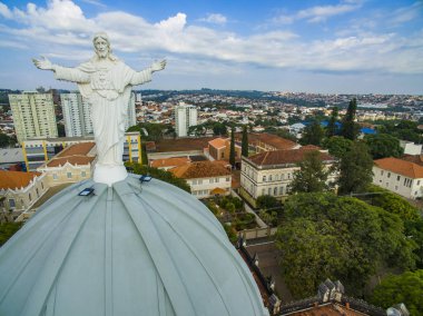 Statue of Jesus Christ on top of the Catholic Church, Cathedral of Sant'Ana, City of Botucatu, Sao Paulo State Brazil South America. Metropolitan Cathedral of Botucatu has Gothic style.  clipart