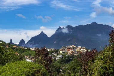 Small town on the hill and the mountain in the background. City of Terespolis, district of Jardim Meudon, state of Rio de Janeiro Brazil, South America.  clipart