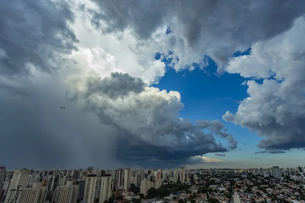 Dark and dramatic clouds of rain. Airplane taking off with storm clouds. Very heavy rain sky in the city of Sao Paulo, Brazil South America.
