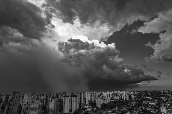 Dark and dramatic clouds of rain. Airplane taking off with storm clouds. Very heavy rain sky in the city of Sao Paulo, Brazil South America. Black and white photo.