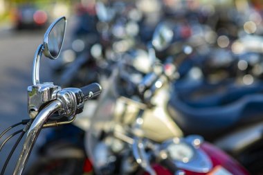 Bir motosikletin kromlu gidonu. Arka planda motosiklet gidon görünümü birçok motosiklet bulanık. 