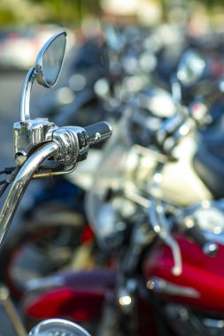 Bir motosikletin kromlu gidonu. Arka planda motosiklet gidon görünümü birçok motosiklet bulanık. 