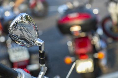 Aynadaki yansımanın güzel görünümü. Güzel, orijinal arka plan. Motosiklet gidonu. Arka planda motosiklet bulanık. 