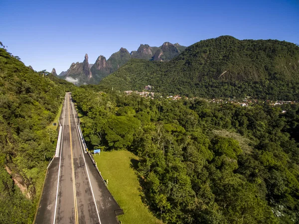 Harika bir yol düz. Tek bir yol. Egzotik dağlar, harika dağlar. Tanrı'nın Parmağı Dağı. Terespolis şehri, Rio de Janeiro eyaleti, Brezilya, Güney Amerika. 