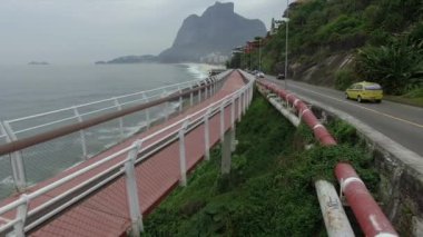 Karayolu deniz kenarında. Harika yolu ve bisiklet yolu. Bisiklet ve yol parça ve mavi denizin içinde Rio de Janeiro şehrine yanında. Tim Maia bisiklet yolu üzerinde Niemeyer Avenue, Rio de Janeiro, Brezilya, Güney Amerika. 