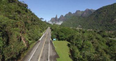 Büyük yol düz. Tek bir yol. Egzotik dağlar, harika dağlar. Tanrı'nın Parmağı Dağı. Teresopolis şehri, Rio de Janeiro Eyaleti, Brezilya, Güney Amerika. 