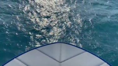 Gemi denizde yelken açar. Geminin önüne bak..