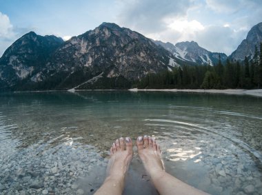 Wonem bacakları Braies Gölü Lago şaşırtıcı bir görünümü ile orman ve dağlar karşı Gölü su Dolomites Alpler, İtalya yansıtıyordu. GoPro hero 5 hero5 üzerinde ele geçirdi. Yürüyüş seyahat ve macera.