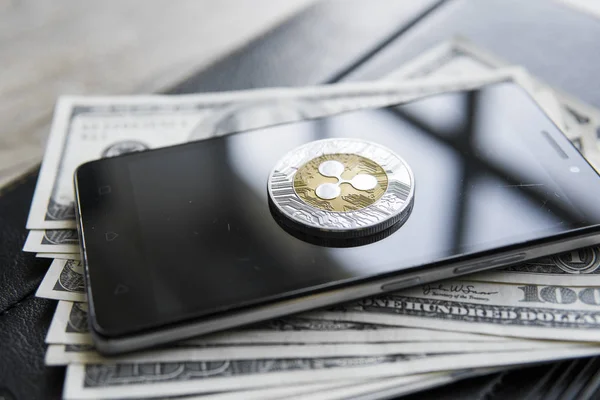 Crypto currency ripple xrp on smartphone and us dollars money background. Blockchain and cyber currency. Global money. Exchange, bussiness, commercial. Cash money and cryptocurrency concept.