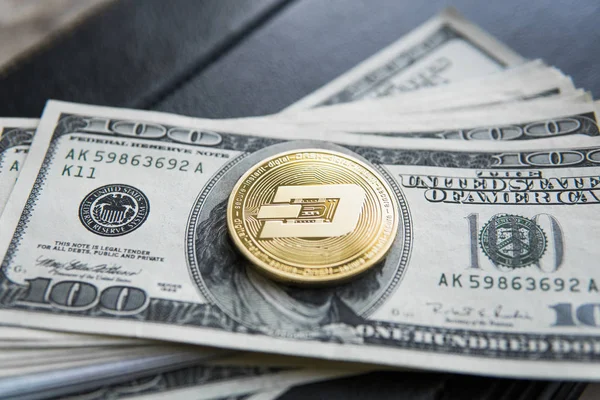 Golden Dash Cryptocurrency coin on a pile of US dollars, and notebook. Cash money and crypto currency concept. Virtual. Exchange. Bussiness, commercial.