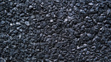 Gün ışığı ile yakalanan siyah taş duvar dokusu.