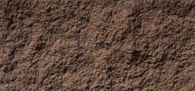 Kahverengi-kirmizi duvar tarafından parlak güneş ışığı yaktı doku taş.