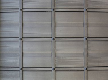 Bir gün ışığında bir kapı üzerinde karanlık aşınmış metal doku.