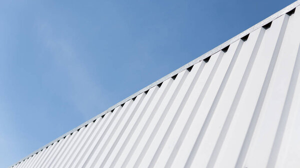 Metal white sheet for industrial building and construction on blue sky background. Roof sheet metal or corrugated roofs of factory building or warehouse