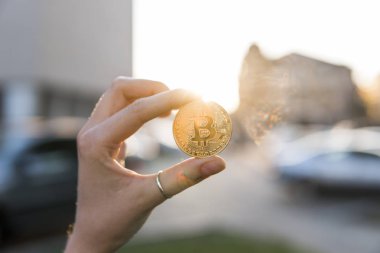 Altın bitcoin para el üzerinde günbatımı arka plan bulanık. Bir kripto para birimi sanal para tutan el. İş, ticaret, Döviz, dijital para.