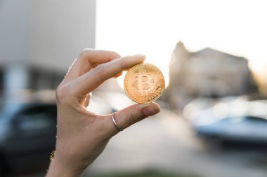 Altın bitcoin para el üzerinde günbatımı arka plan bulanık. Bir kripto para birimi sanal para tutan el. İş, ticaret, Döviz, dijital para.