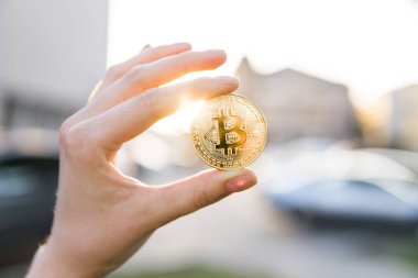 Altın bitcoin para el üzerinde günbatımı arka plan bulanık. Bir kripto para birimi sanal para tutan el. İş, ticaret, Döviz, dijital para.