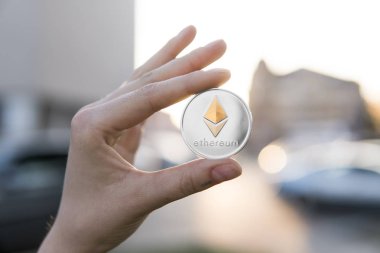 Altın Gümüş Ethereum para el üzerinde günbatımı arka plan bulanık. Bir kripto para birimi sanal para tutan el. İş, ticaret, Döviz, dijital para.