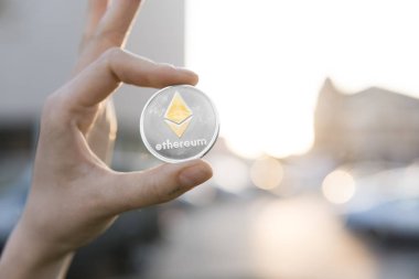 Altın Gümüş Ethereum para el üzerinde günbatımı arka plan bulanık. Bir kripto para birimi sanal para tutan el. İş, ticaret, Döviz, dijital para.