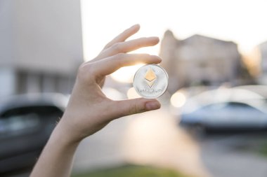 Altın Gümüş Ethereum para el üzerinde günbatımı arka plan bulanık. Bir kripto para birimi sanal para tutan el. İş, ticaret, Döviz, dijital para.