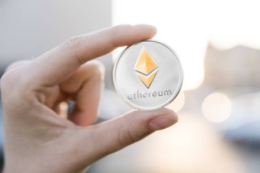 Altın Gümüş Ethereum para el üzerinde günbatımı arka plan bulanık. Bir kripto para birimi sanal para tutan el. İş, ticaret, Döviz, dijital para.