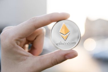 Altın Gümüş Ethereum para el üzerinde günbatımı arka plan bulanık. Bir kripto para birimi sanal para tutan el. İş, ticaret, Döviz, dijital para.