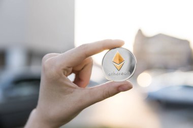 Altın Gümüş Ethereum para el üzerinde günbatımı arka plan bulanık. Bir kripto para birimi sanal para tutan el. İş, ticaret, Döviz, dijital para