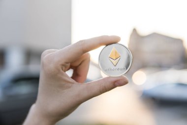 Altın Gümüş Ethereum para el üzerinde günbatımı arka plan bulanık. Bir kripto para birimi sanal para tutan el. İş, ticaret, Döviz, dijital para.