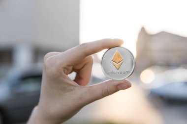 Altın Gümüş Ethereum para el üzerinde günbatımı arka plan bulanık. Bir kripto para birimi sanal para tutan el. İş, ticaret, Döviz, dijital para.