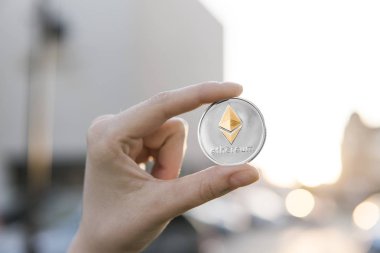 Altın Gümüş Ethereum para el üzerinde günbatımı arka plan bulanık. Bir kripto para birimi sanal para tutan el. İş, ticaret, Döviz, dijital para.