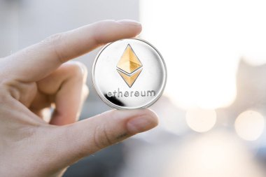 Altın Gümüş Ethereum para el üzerinde günbatımı arka plan bulanık. Bir kripto para birimi sanal para tutan el. İş, ticaret, Döviz, dijital para.