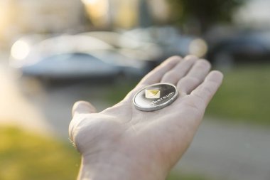 Altın Gümüş Ethereum para el üzerinde günbatımı arka plan bulanık. Bir kripto para birimi sanal para tutan el. İş, ticaret, Döviz, dijital para.