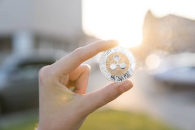Altın Gümüş dalgalanma sikke elinde günbatımı arka plan bulanık. Bir kripto para birimi sanal para tutan el. İş, ticaret, Döviz, dijital para.