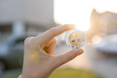 Altın Gümüş dalgalanma sikke elinde günbatımı arka plan bulanık. Bir kripto para birimi sanal para tutan el. İş, ticaret, Döviz, dijital para.