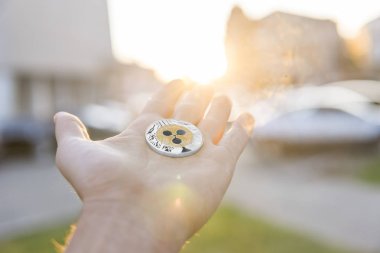 Altın Gümüş dalgalanma sikke elinde günbatımı arka plan bulanık. Bir kripto para birimi sanal para tutan el. İş, ticaret, Döviz, dijital para.