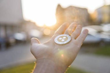 Altın Gümüş dalgalanma sikke elinde günbatımı arka plan bulanık. Bir kripto para birimi sanal para tutan el. İş, ticaret, Döviz, dijital para.