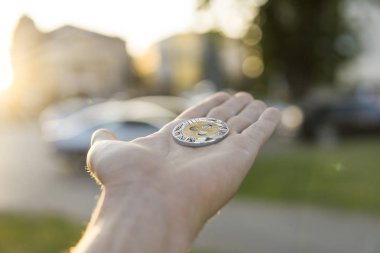 Altın Gümüş dalgalanma sikke elinde günbatımı arka plan bulanık. Bir kripto para birimi sanal para tutan el. İş, ticaret, Döviz, dijital para.