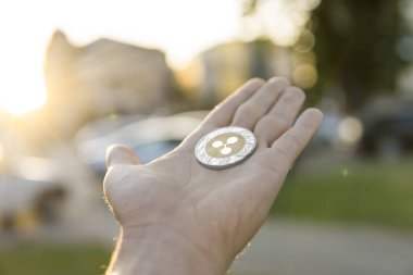 Altın Gümüş dalgalanma sikke elinde günbatımı arka plan bulanık. Bir kripto para birimi sanal para tutan el. İş, ticaret, Döviz, dijital para.