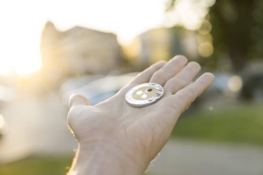 Altın Gümüş dalgalanma sikke elinde günbatımı arka plan bulanık. Bir kripto para birimi sanal para tutan el. İş, ticaret, Döviz, dijital para.