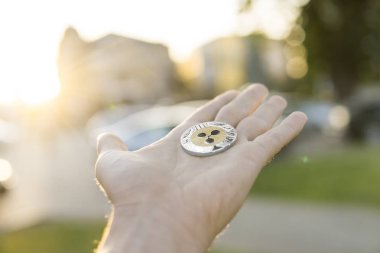 Altın Gümüş dalgalanma sikke elinde günbatımı arka plan bulanık. Bir kripto para birimi sanal para tutan el. İş, ticaret, Döviz, dijital para.