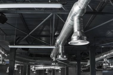 Büyük binaların tavanındaki havalandırma sistemi. Yeni binanın tavanından sarkan gümüş yalıtım malzemelerindeki havalandırma boruları..