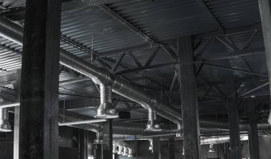 Büyük binaların tavanındaki havalandırma sistemi. Yeni binanın tavanından sarkan gümüş yalıtım malzemelerindeki havalandırma boruları..