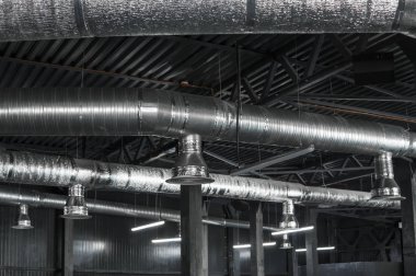 Büyük binaların tavanındaki havalandırma sistemi. Yeni binanın tavanından sarkan gümüş yalıtım malzemelerindeki havalandırma boruları..