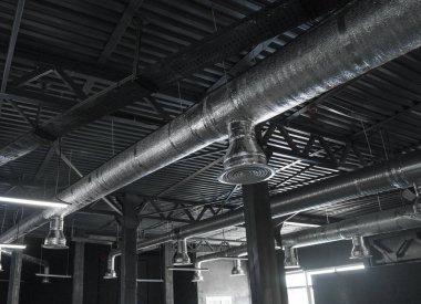 Büyük binaların tavanındaki havalandırma sistemi. Yeni binanın tavanından sarkan gümüş yalıtım malzemelerindeki havalandırma boruları..