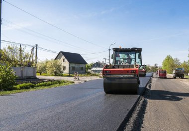 Asfalt kaplama yeni yol inşaat site üzerinde çalışan, ağır titreşim silindir. Onarma.