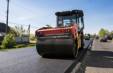 Asfalt kaplama yeni yol inşaat site üzerinde çalışan, ağır titreşim silindir. Onarma.